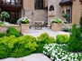 A backyard patio framed by stonework and lovely flower beds